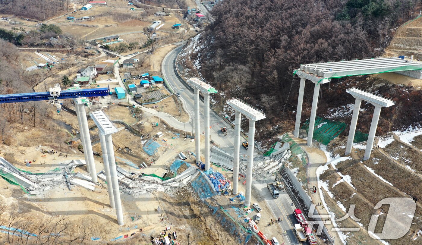 본문 이미지 - 25일 오후 경기도 안성시 서운면 서울-세종고속도로 다리 건설현장에서 교량이 붕괴된 모습이 보이고 있다. 이날 소방서에 따르면 공사 현장에서는 빔 설치를 위한 장비를 이동하다 철제 구조물이 무너지며 교각 위 설치된 가로 콘크리트 지지대가 땅 아래로 떨어졌다. 2025.2.25/뉴스1 ⓒ News1 이승배 기자