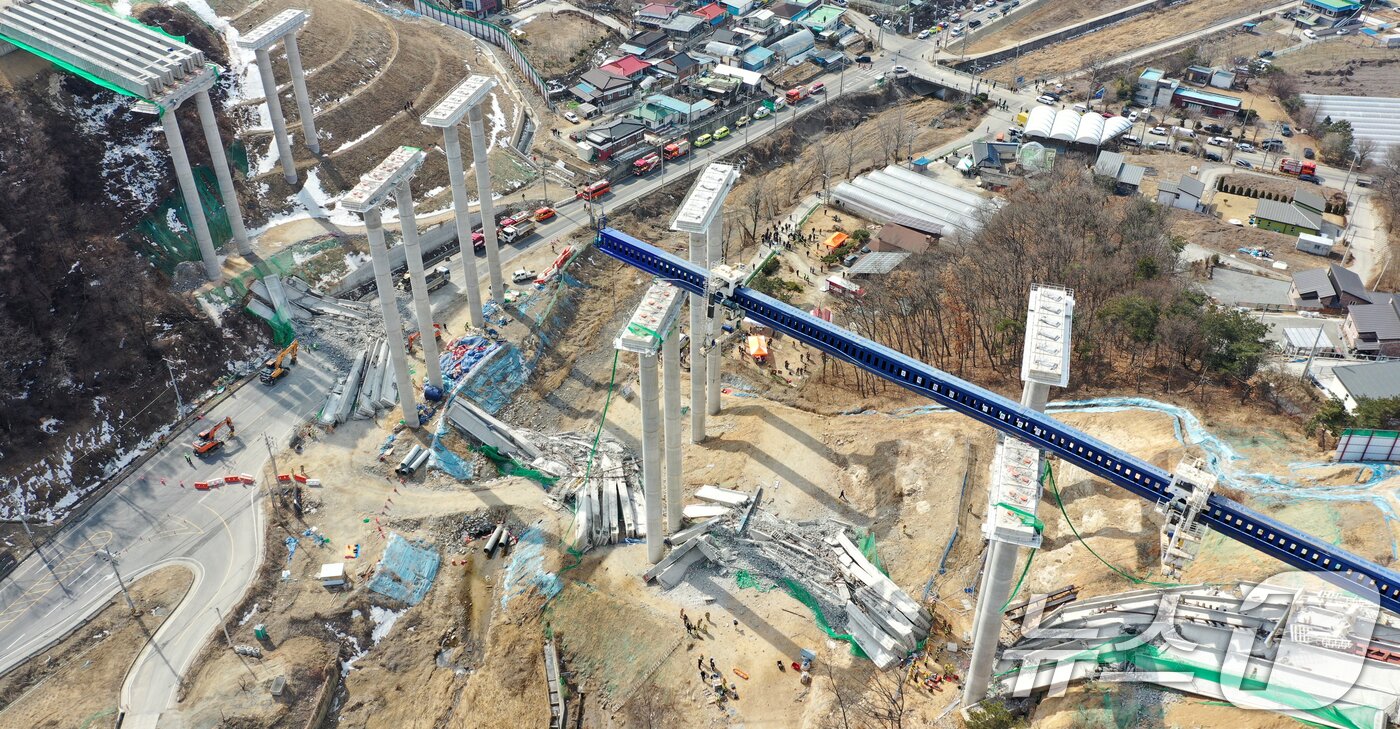 본문 이미지 - 25일 오후 경기도 안성시 서운면 서울-세종고속도로 다리 건설현장에서 교량이 붕괴된 모습이 보이고 있다. 이날 소방서에 따르면 공사 현장에서는 빔 설치를 위한 장비를 이동하다 철제 구조물이 무너지며 교각 위 설치된 가로 콘크리트 지지대가 땅 아래로 떨어졌다. 2025.2.25/뉴스1 ⓒ News1 이승배 기자