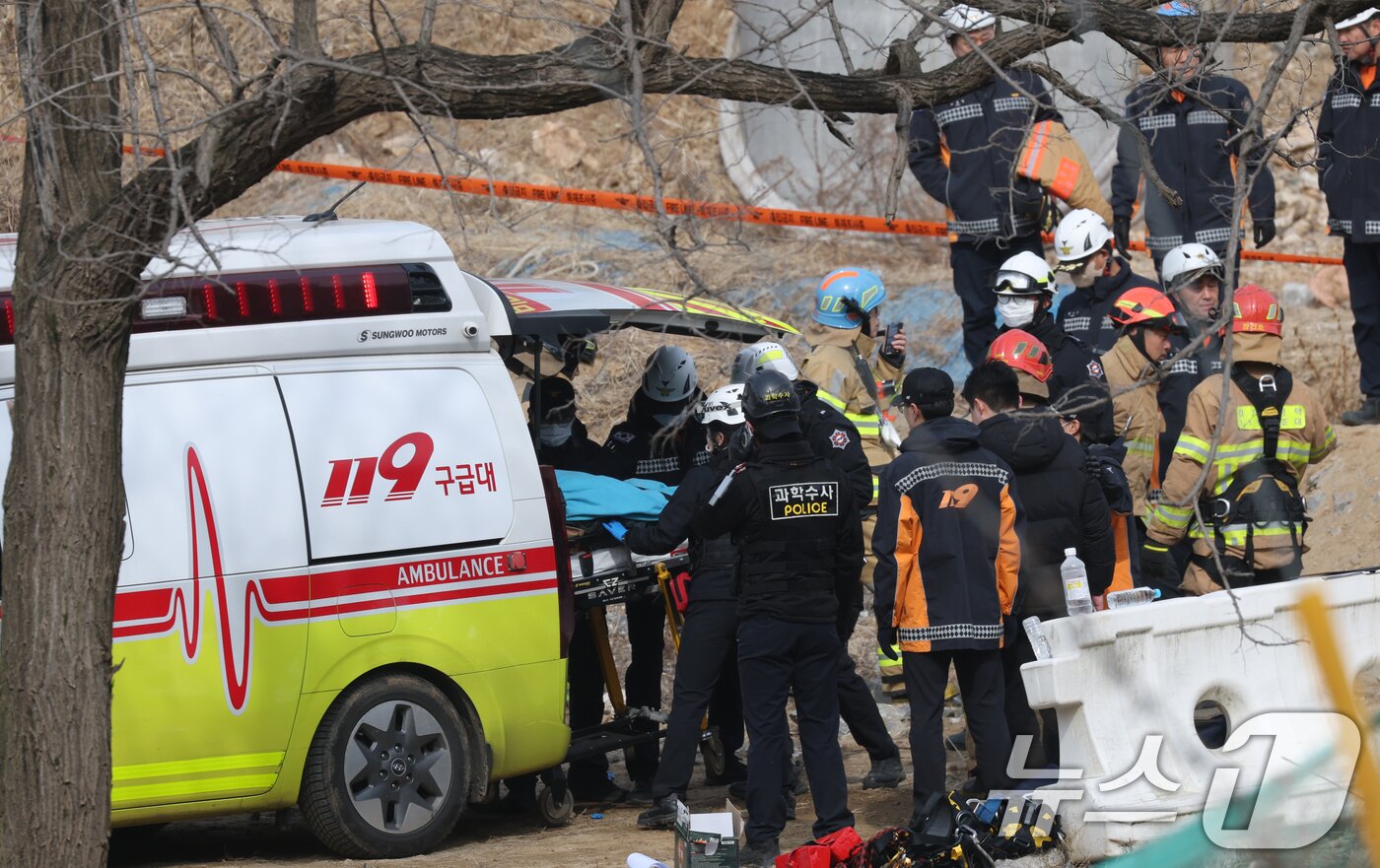 본문 이미지 - 25일 경기 안성시 서운면 산평리 서울-세종고속도로 다리 건설현장에서 철근 구조물이 교각 아래로 떨어져 소방관들이 수색 작업을 마친 뒤 매몰자를 이송하고 있다. 이번 사고로 작업자 10명이 매몰되는 사고가 발생, 4명이 사망했다. 2025.2.25/뉴스1 ⓒ News1 김영운 기자