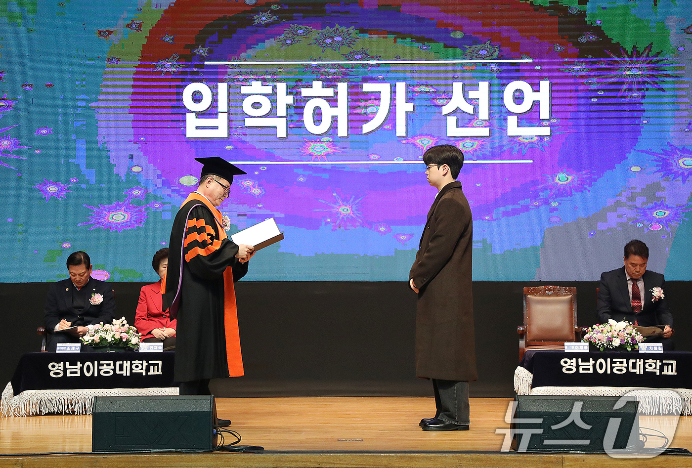 (대구=뉴스1) 공정식 기자 = 25일 대구 남구 영남이공대 천마체육관에서 열린 '2025학년도 신입생 입학식'에서 이재용 총장(왼쪽)이 입학허가 선언을 하고 있다.이재용 총장은 …