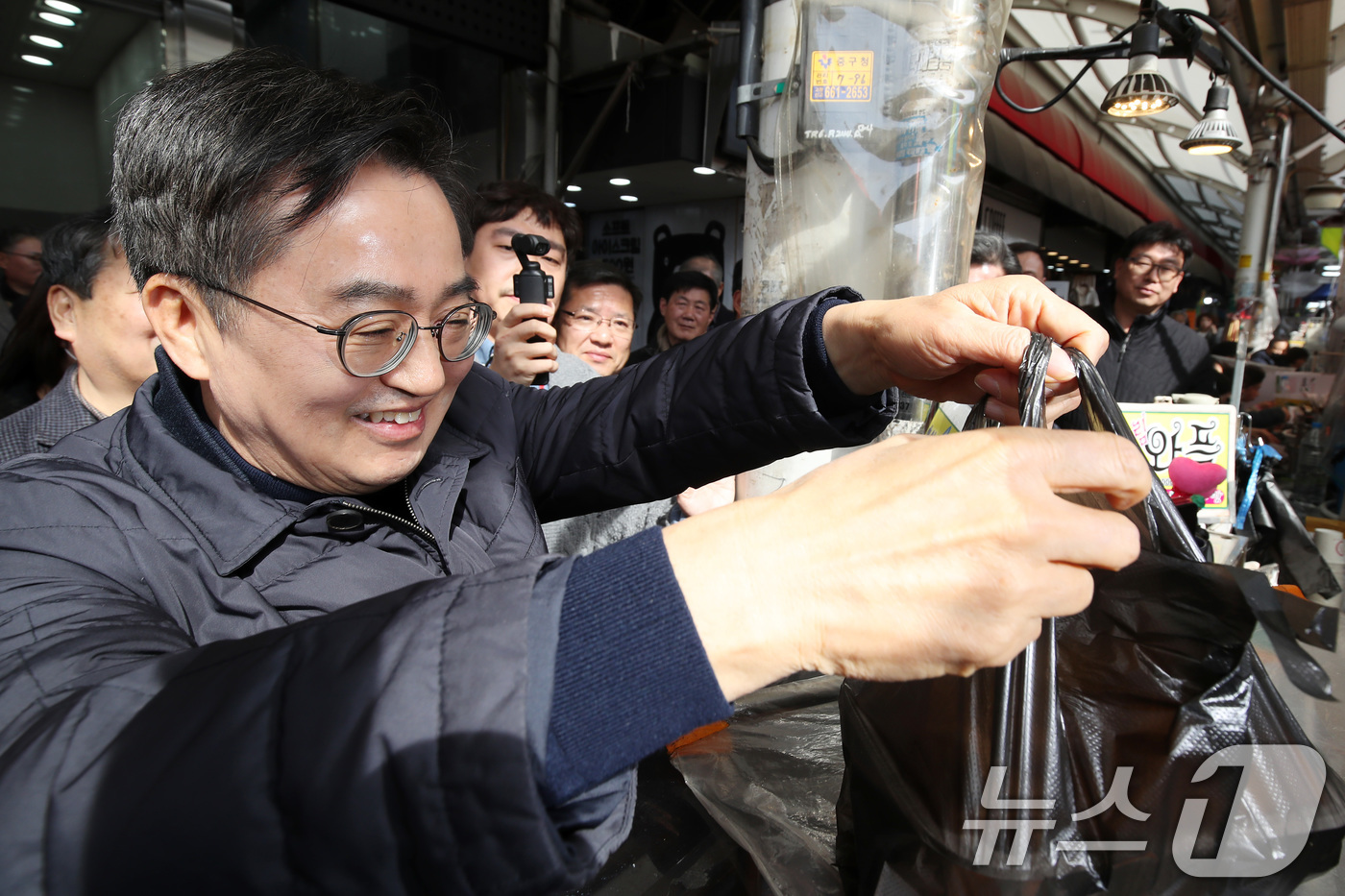 (대구=뉴스1) 공정식 기자 = 김동연 경기도지사가 27일 오후 대구 중구 서문시장을 찾아 상인과 인사 나눈 뒤 국화빵을 사고 있다. 2025.2.27/뉴스1