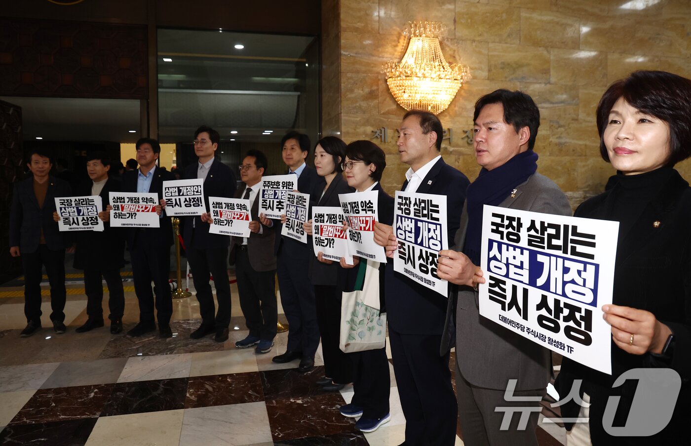 본문 이미지 - 더불어민주당 주식시장 활성화 TF 소속 의원들이 27일 오후 서울 여의도 국회 본회의장 앞에서 국민의힘의 상법 개정 이행을 촉구하는 규탄 피켓을 들고 구호를 외치고 있다. 2025.2.27/뉴스1 ⓒ News1 김민지 기자
