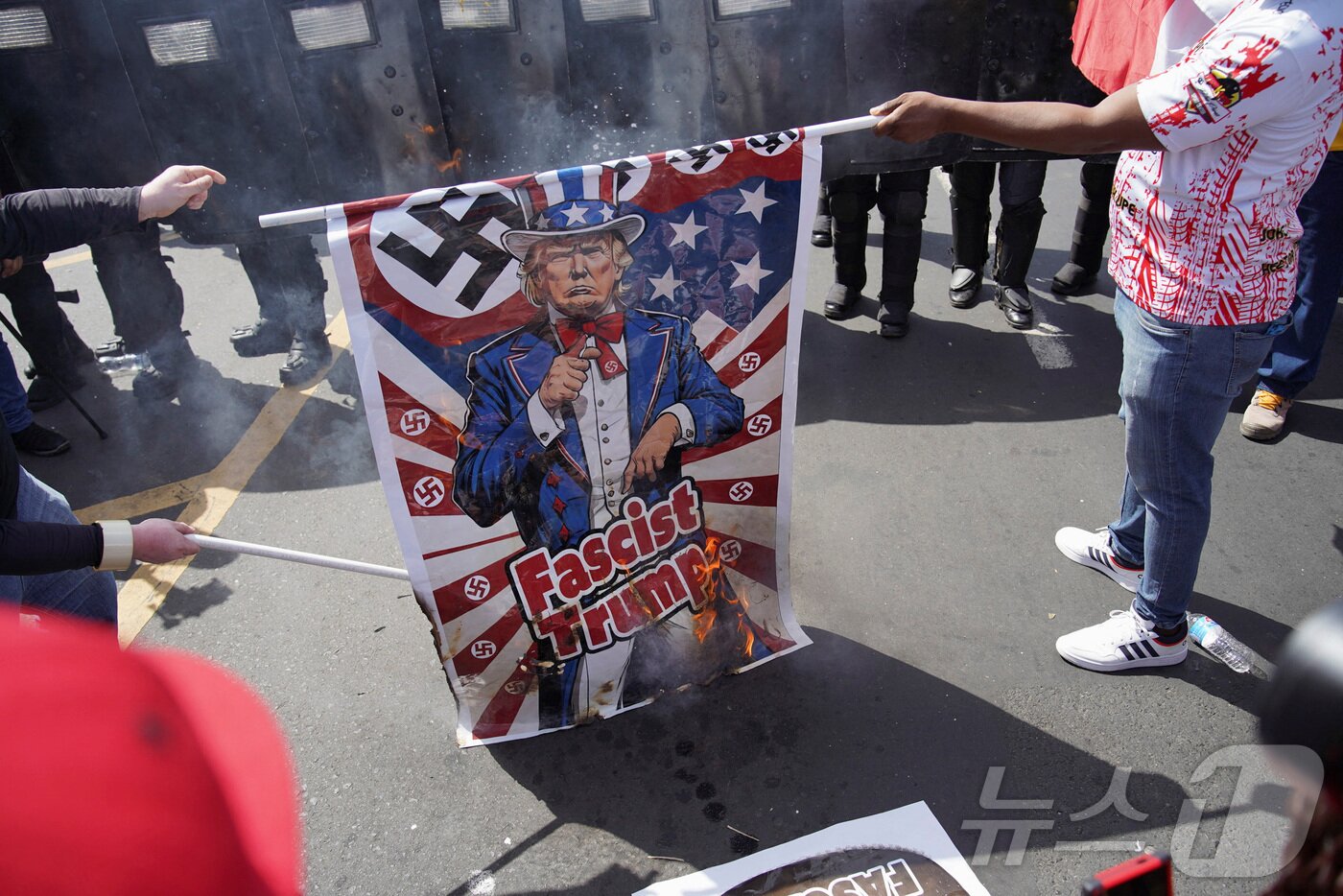 본문 이미지 - 마르코 루비오 미국 국무장관이 호세 라울 물리노 대통령과 파나마 운하와 이민을 논의하기 위해 방문을 한 가운데, 2일&#40;현지시간&#41; 파나마시티에서 군중이 도널드 트럼프 미국 대통령이 그려진 깃발을 태우는 시위를 벌이고 있다. ⓒ 로이터=뉴스1 ⓒ News1 류정민 특파원