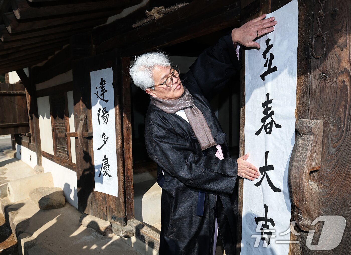 본문 이미지 - 절기상 입춘(立春)인 3일 서울 종로구 국립민속박물관 내 오촌댁 대문에 서예가가 입춘첩을 붙이고 있다. 입춘첩의 '입춘대길(立春大吉) 건양다경(建陽多慶)' 문구에는 봄을 기다리는 마음과 한 해 행운과 경사스러움이 가득하기를 기원하는 의미가 담겼다. 2024.2.3/뉴스1 ⓒ News1 오대일 기자