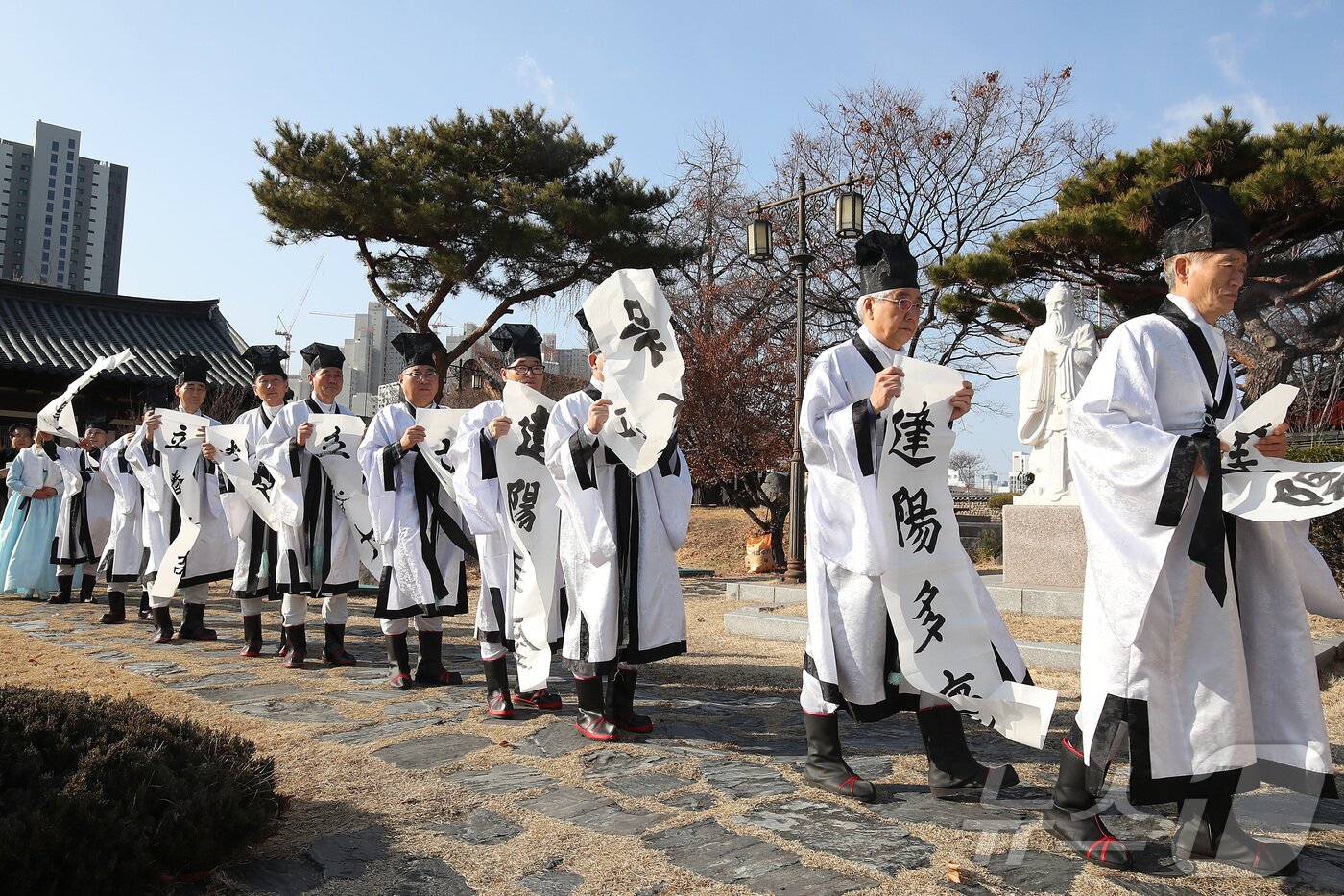 본문 이미지 - 봄의 시작을 알리는 절기 '입춘(立春)'을 맞아 3일 오전 대구 중구 남산동 대구향교에서 유림들이 붓글씨로 쓴 '입춘대길·건양다경' 입춘첩을 외삼문에 붙이기 위해 찬바람을 맞으며 걸어가고 있다. 2025.2.3/뉴스1 ⓒ News1 공정식 기자