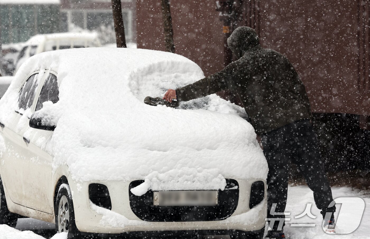 본문 이미지 - 4일 광주 광산구 한 아파트에서 시민이 차에 쌓인 눈을 치우고 있다. 2025.2.4./뉴스1 ⓒ News1 김태성 기자