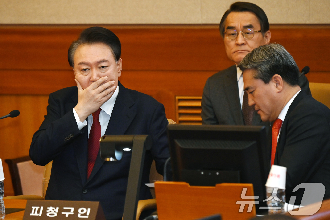 (서울=뉴스1) 사진공동취재단 = 윤석열 대통령이 6일 오전 서울 종로구 헌법재판소 대심판정에서 열린 탄핵심판 6차 변론기일에 출석해 입을 가리고 변호인과 대화하고 있다. 2025 …