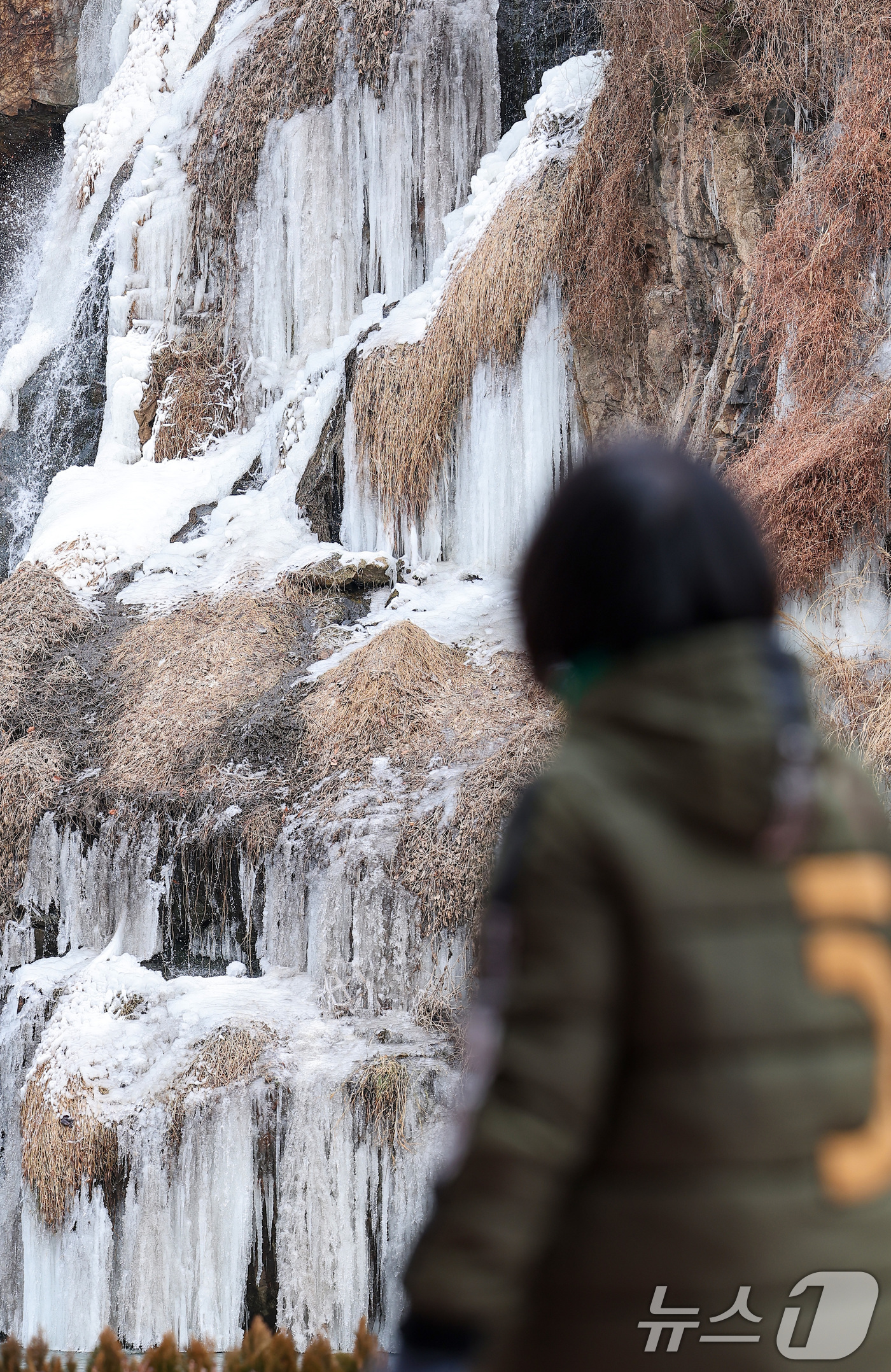 (서울=뉴스1) 김성진 기자 = 한파가 이어진 6일 얼어붙은 서울 서대문구 홍제천 인공폭포 앞으로 한 시민이 지나가고 있다. 2025.2.6/뉴스1