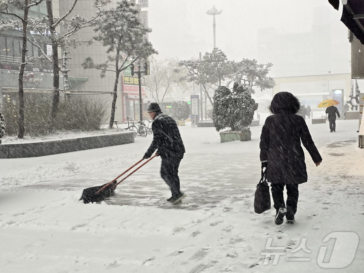 (고양=뉴스1) 황덕현 기후환경전문기자 = 6일 오후 경기 고양 덕양구 화정역 인근에 많은 눈이 내린 가운데 시민들이 점포 앞에 쌓인 눈을 치우고 있다. 2025.2.6/뉴스1