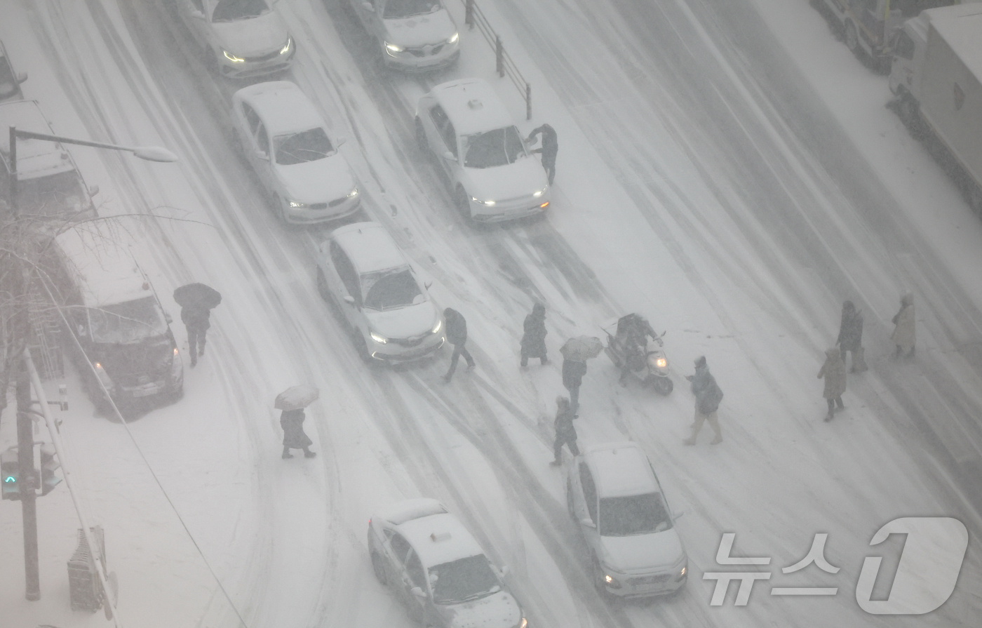 (서울=뉴스1) 김도우 기자 = 서울에 대설주의보가 내려진 6일 오후 서울 종로구 종각역 인근 도로에서 차량들이 서행하고 있다. 2025.2.6/뉴스1