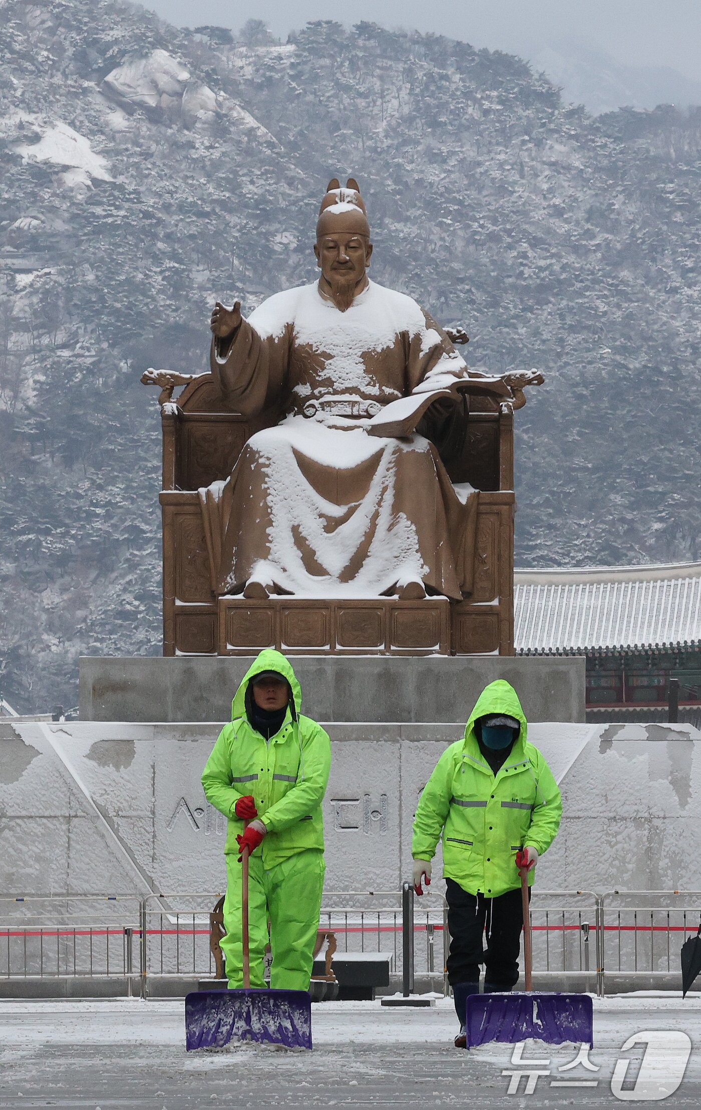 본문 이미지 - 강추위 속 전국 곳곳에 눈이 내린 7일 오전 서울 종로구 광화문 광장 일대에서 종로구 관계자들이 제설작업을 하고 있다. 2025.2.7/뉴스1 ⓒ News1 임세영 기자
