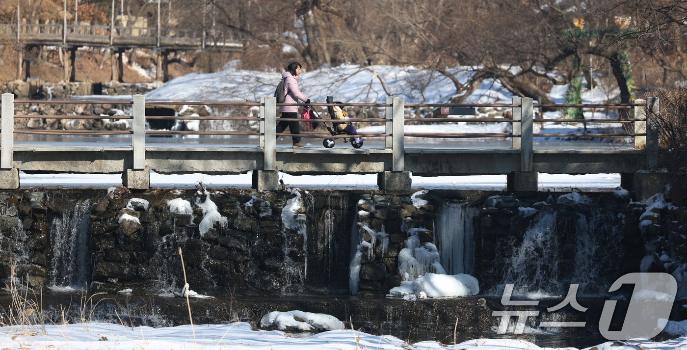(용인=뉴스1) 김영운 기자 = 추운 날씨가 이어지고 있는 9일 경기 용인시 기흥구 한국민속촌을 찾은 가족이 다리를 건너고 있다. 2025.2.9/뉴스1