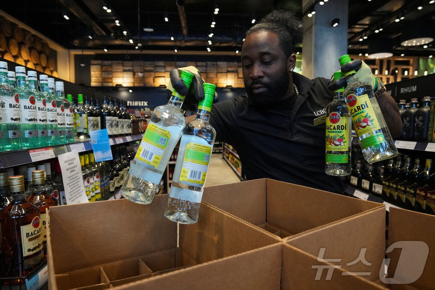 본문 이미지 - 캐나다 온타리오주 토론토에서 도널드 트럼프 미국 대통령이 발표한 관세에 대한 보복 조치의 일환으로 온타리오주 주류관리위원회&#40;LCBO&#41; 매장 직원이 선반에서 미국 주류를 수거 하고 있다. ⓒ 로이터=뉴스1