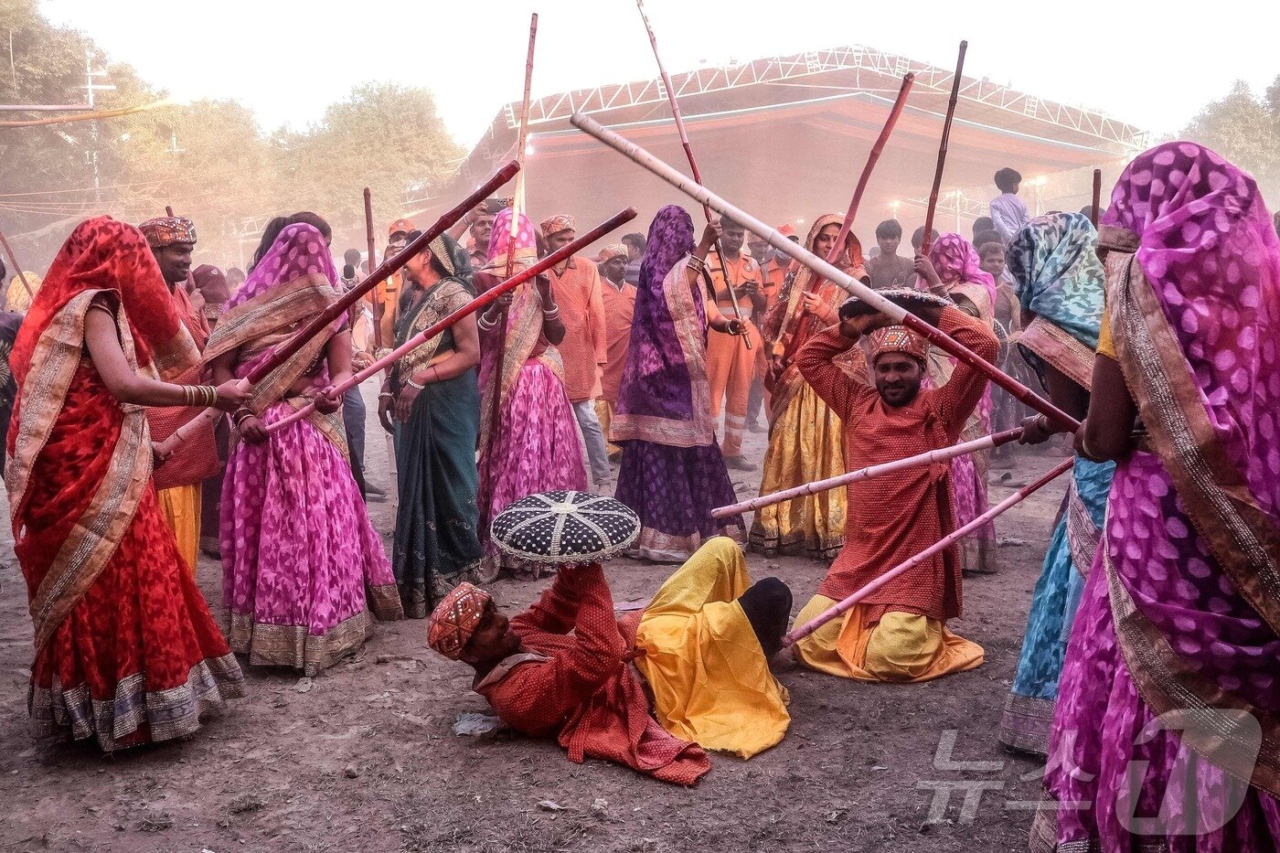 본문 이미지 - 10일 인도 북부 우타르프라데시주 마투라에서 힌두교의 봄 색채 축제인 라트마르 홀리(Lathmar Holi) 축제에서 여성들이 전통 의식 일환으로 막대기로 남성들을 때리고 있다.  ⓒ AFP=뉴스1