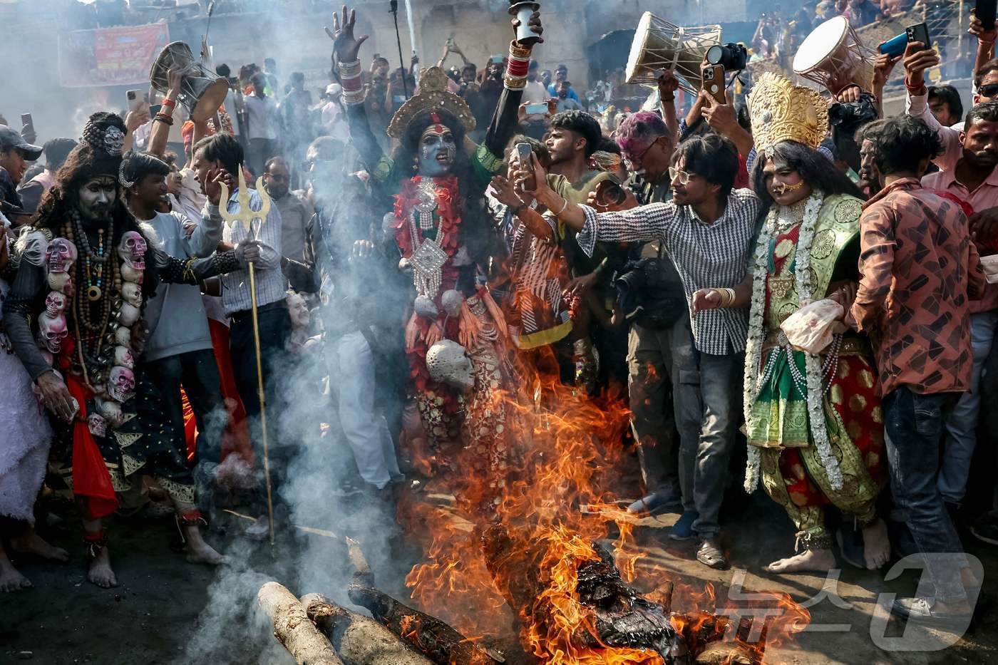 본문 이미지 - 10일(현지시간) 인도 바라나시의 하리쉬찬드라 가트 갠지스강 인근에서 시민들이 불타는 장례식 장작더미 앞에서 춤을 추고 있습니다.  ⓒ AFP=뉴스1