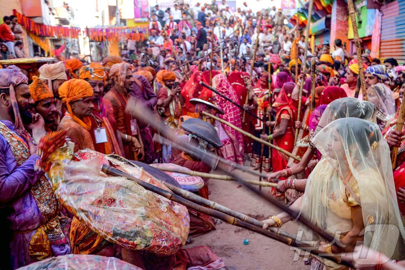 본문 이미지 - 8일 인도 북부 우타르프라데시주 바르사나에서 힌두교의 봄 색채 축제인 '라트마르 홀'에서 여성들이 막대기로 때리는 전통 의식을 하고 있다.ⓒ AFP=뉴스1