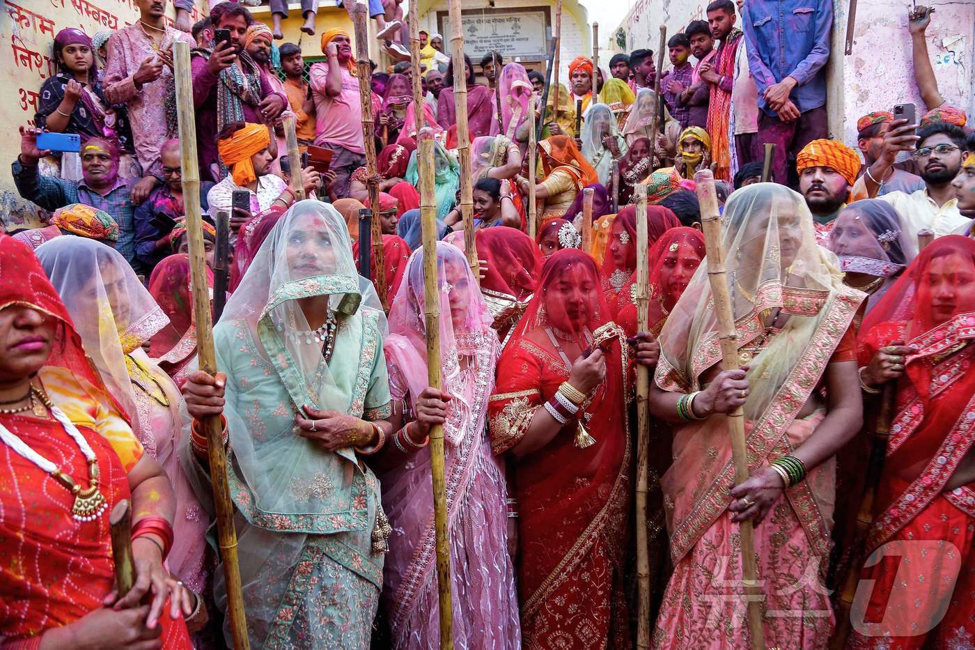 본문 이미지 - 8일 인도 북부 우타르프라데시주 바르사나에서 힌두교의 봄 축제 '라트마르 홀리'에서 막대기를 든 여성들이 포즈를 취하고 있다. ⓒ AFP=뉴스1