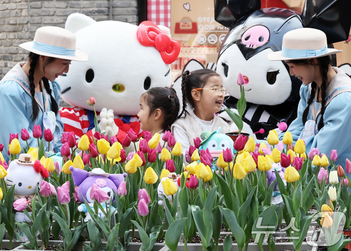 본문 이미지 - 11일 오전 서울 중구 명동 &#39;헬로키티 애플카페 앞에서 헬로키티와 쿠로미 캐릭터들이 에버랜드 튤립축제 개막을 알리기 위해 어린이들에게 싱그러운 튤립 화분을 선물하고 있다.  2025.3.11/뉴스1 ⓒ News1 오대일 기자