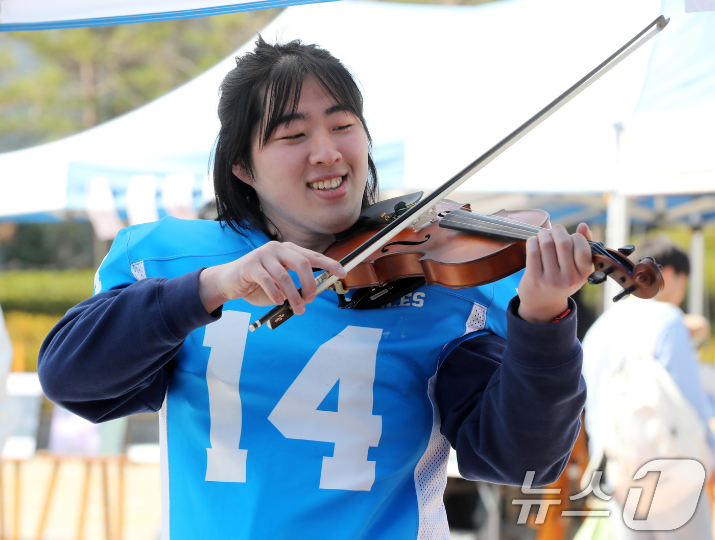 (부산=뉴스1) 윤일지 기자 = 11일 부산 금정구 부산대학교 시월광장에서 열린 동아리 신입 회원 모집 행사에서 미식축구 동아리 회원이 오케스트라 동아리 체험을 하고 있다. 202 …