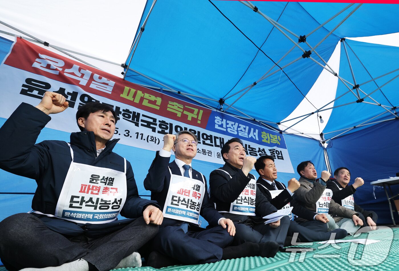 본문 이미지 - &#39;윤석열 탄핵 국회의원 연대&#39; 소속 야당 의원들이 11일 오후 서울 종로구 경복궁역 앞 천막 농성장에서 윤석열 대통령 파면 촉구 단식농성에 돌입하며 구호를 외치고 있다. 왼쪽부터 한창민 사회민주당 대표, 민형배 더불어민주당 의원, 박수현 더불어민주당 의원, 윤종오 진보당 원내대표, 김준혁 더불어민주당 의원, 강득구 더불어민주당 의원. 2025.3.11/뉴스1 ⓒ News1 오대일 기자