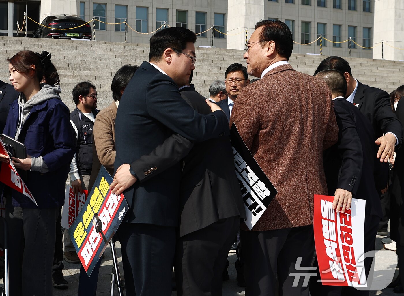 본문 이미지 - 박찬대 더불어민주당 원내대표가 11일 오후 서울 여의도 국회 본청 앞에서 열린 박홍배, 김문수, 전진숙 의원의 윤석열 대통령 조기 파면 촉구 삭발식에서 삭발을 마친 의원들을 안아주고 있다. 2025.3.11/뉴스1 ⓒ News1 김민지 기자
