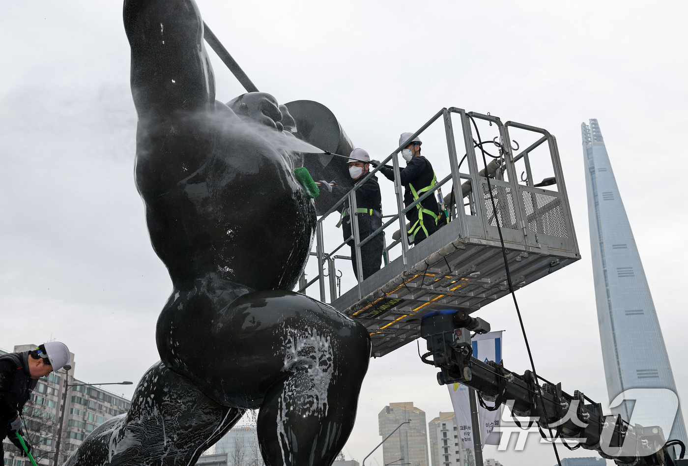 (서울=뉴스1) 오대일 기자 = 송파구 관계자들이 12일 서울 송파구 올림픽로에 설치된 올림픽 상징 역도 조형물을 고압 세척기를 이용해 물 청소를 하고 있다. 송파구는 봄을 맞아 …