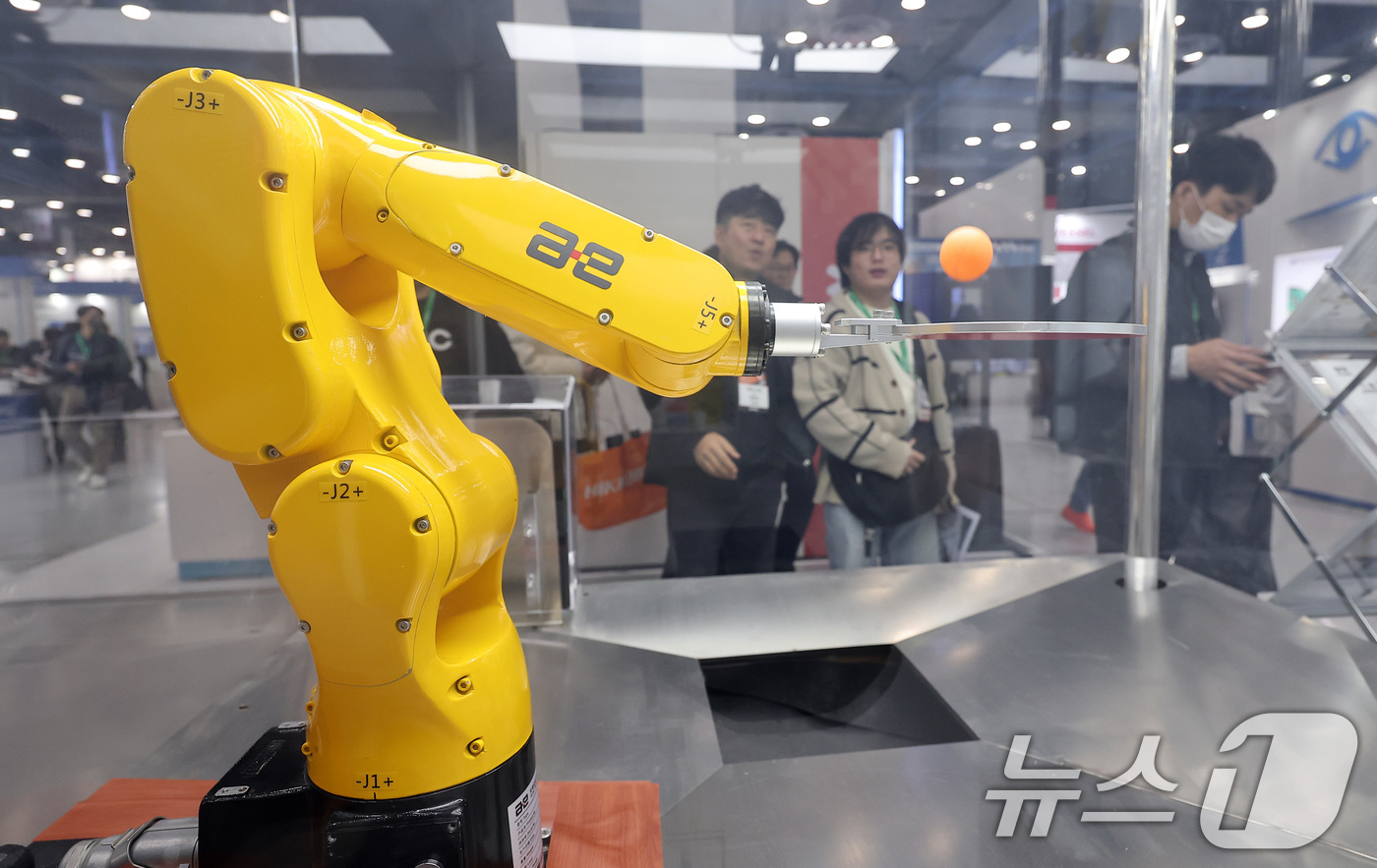 (서울=뉴스1) 김성진 기자 = 12일 서울 강남구 코엑스에서 열린 2025 스마트공장·자동화산업전를 찾은 관람객들이 탁구공을 튀기는 다관절 로봇 시연을 관전하고 있다. 2025. …