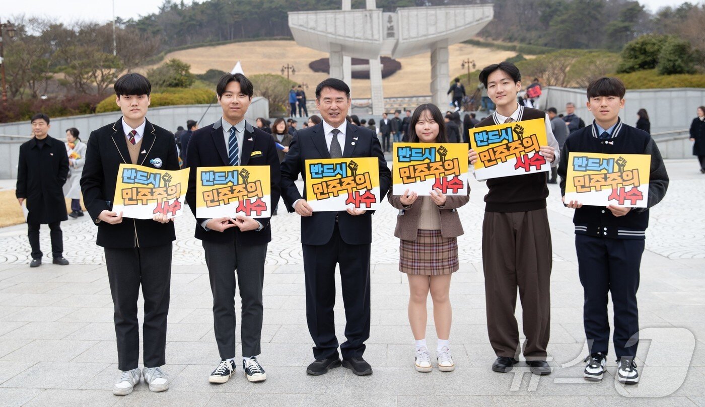 본문 이미지 - 이정선 광주교육감이 12일 광주 북구 운정동 5·18민주묘지서 열린 5·18행사위 출범식에 광주 고교 학생의회 의장단과 참석해 ‘반드시 민주주의 사수’라 적힌 피켓을 들고 있다.(광주교육청 제공. 재배포 및 DB 금지)