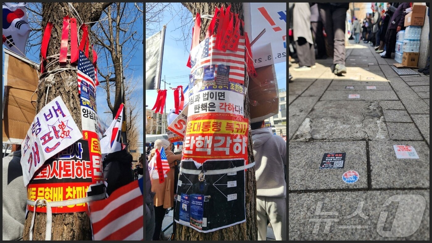 본문 이미지 - 13일 서울시 종로구 헌법재판소 앞 가로수에 각종 탄핵 반대를 주장하는 유인물과 헌법 재판관을 욕하는 피켓 등이 붙어 있다. 도로에도 탄핵 반대 관련 게시글을 홍보하는 스티커가 깔려 있다. 2025.03.13/ⓒ 뉴스1 권진영 기자