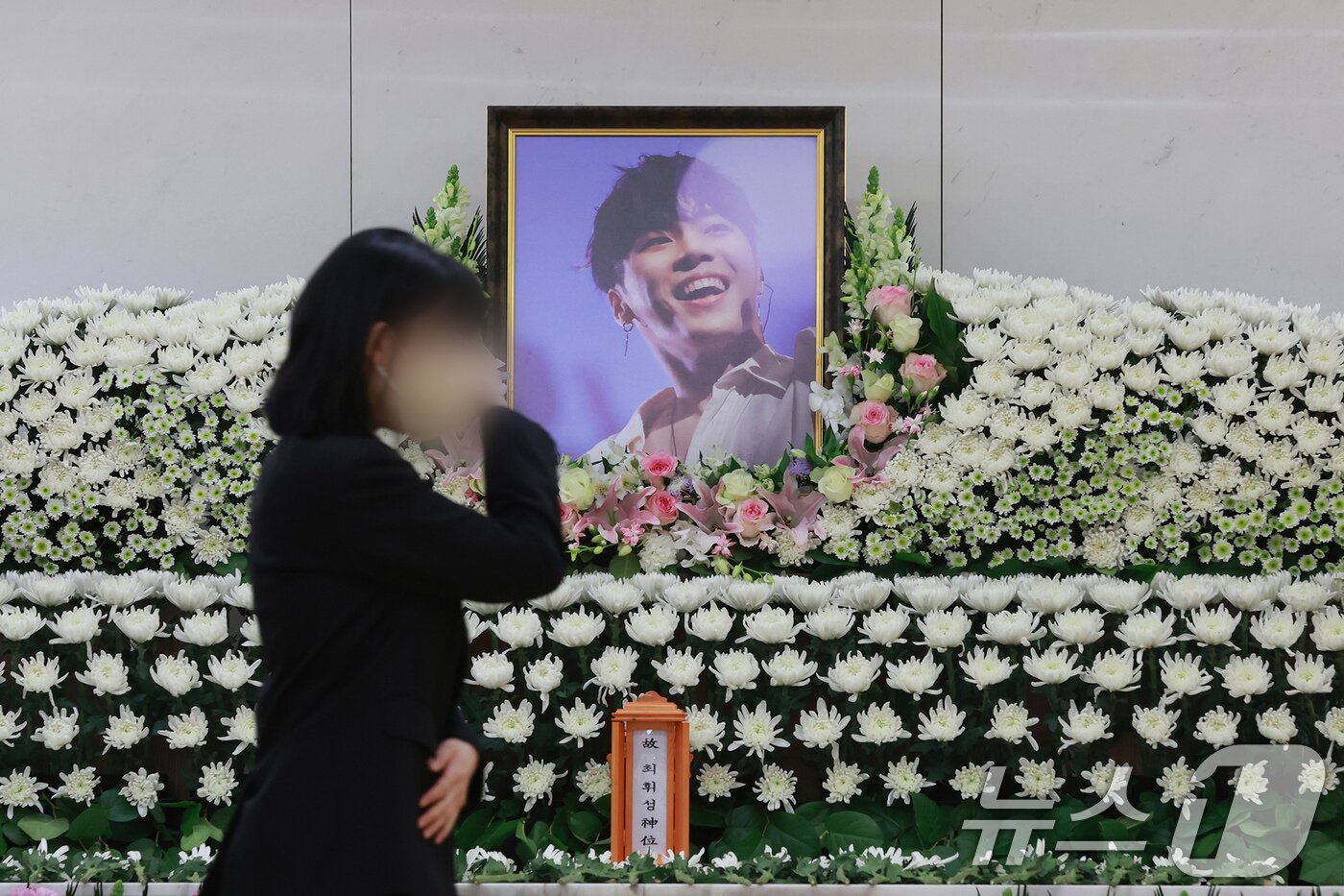 본문 이미지 - 故 휘성의 빈소가 14일 서울 강남구 삼성서울병원 장례식장에 마련된 가운데 한 조문객이 고인과의 마지막 인사를 나누며 눈물을 훔치고 있다.  ⓒ News1 사진공동취재단