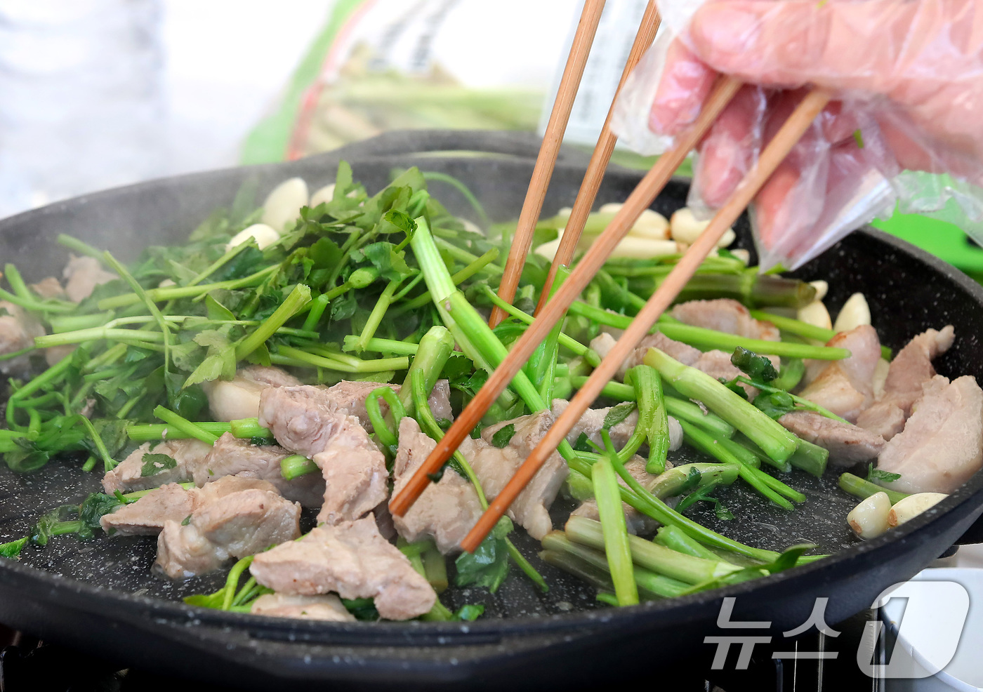 (대구=뉴스1) 공정식 기자 = 14일 대구 달서구 옛 두류정수장 터에서 열린 '미삼(미나리·삼겹살) 소비촉진 행사'를 찾은 시민들이 싱싱한 미나리와 삼겹살을 맛깔나게 굽고 있다. …