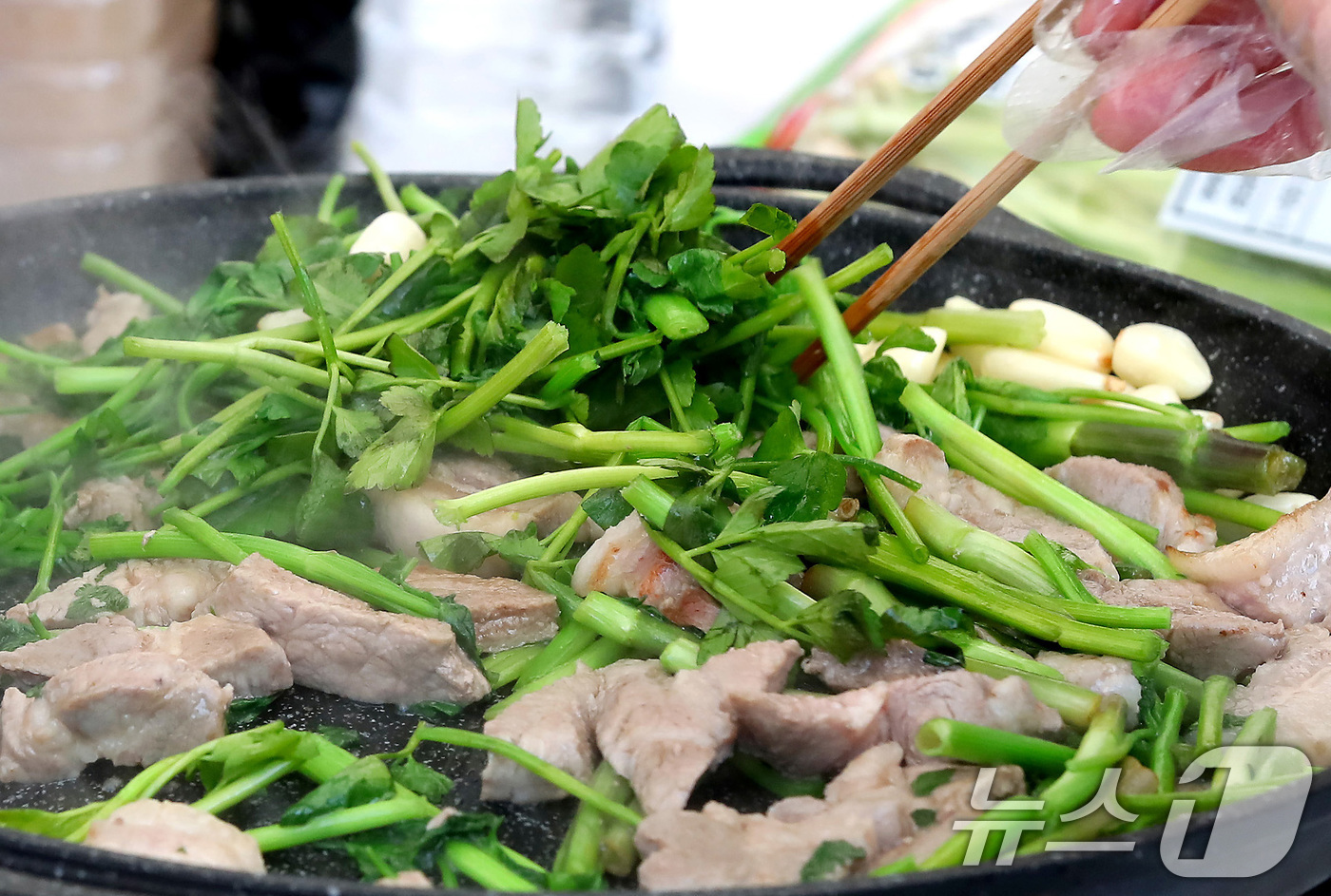 (대구=뉴스1) 공정식 기자 = 14일 대구 달서구 옛 두류정수장 터에서 열린 '미삼(미나리·삼겹살) 소비촉진 행사'를 찾은 시민들이 싱싱한 미나리와 삼겹살을 맛깔나게 굽고 있다. …