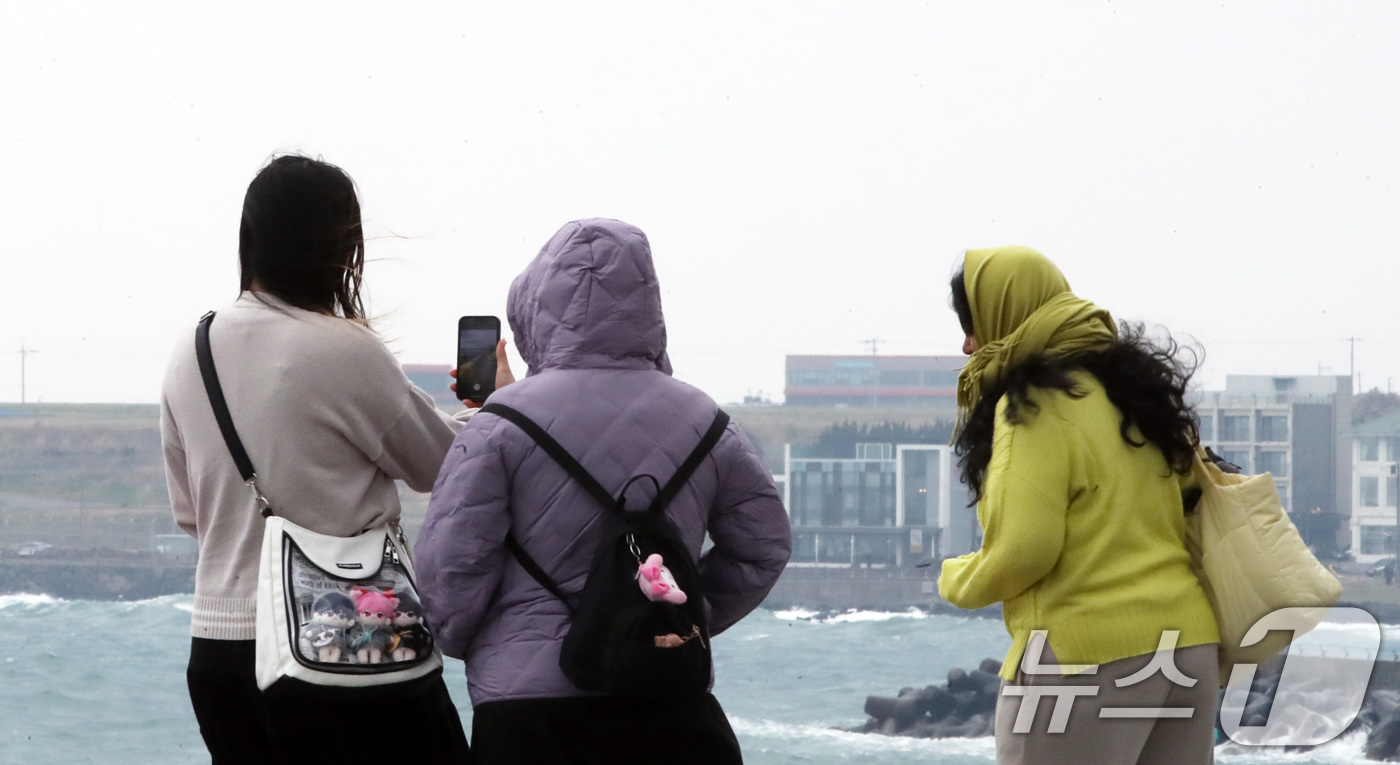 (제주=뉴스1) 오현지 기자 = 평년보다 높았던 기온이 뚝 떨어진 16일 오전 제주시 도두동 무지개 해안도로에서 패딩을 입은 관광객들이 사진을 찍고 있다.기상청은 17일 전국 대부 …