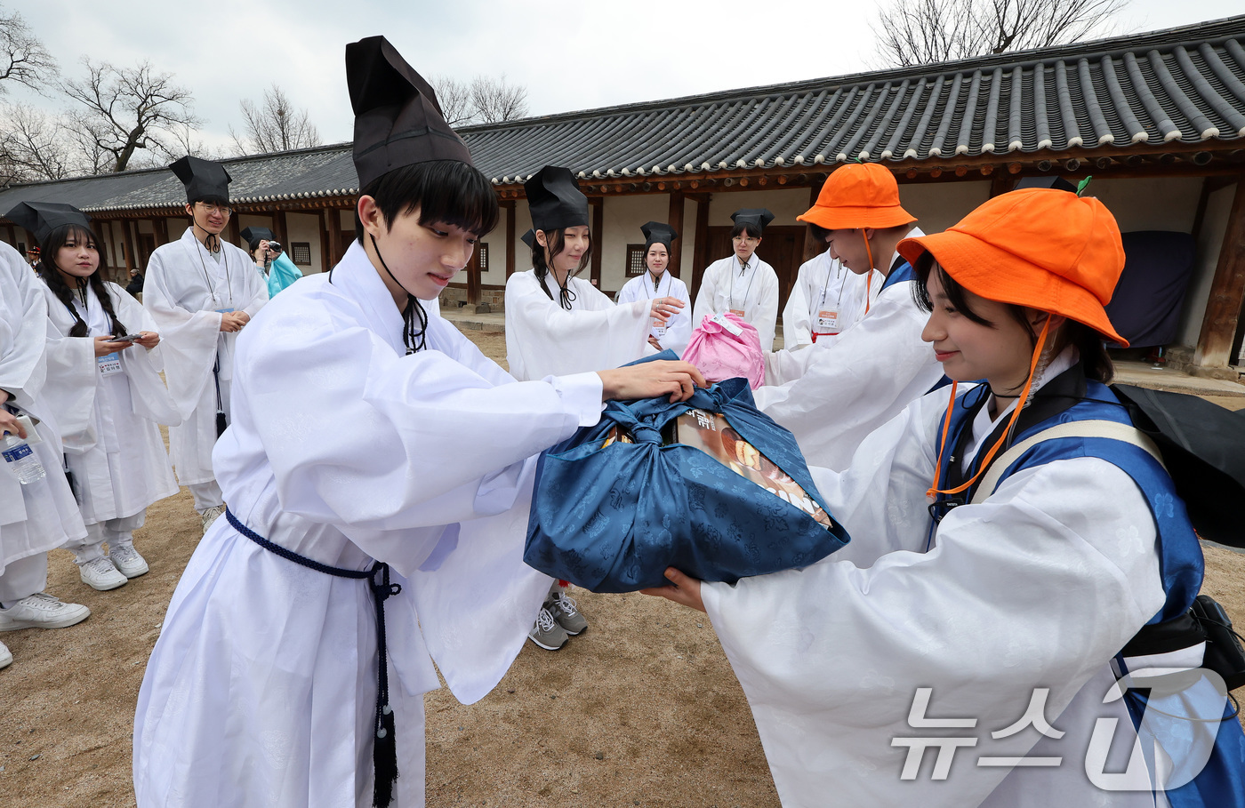 (서울=뉴스1) 이동해 기자 = 16일 서울 종로구 성균관대학교 명륜당에서 열린 2025년 신방례 행사에서 신입생들이 준비한 음식을 선배에게 건네며 친목을 다지는 소신방례를 재현하 …