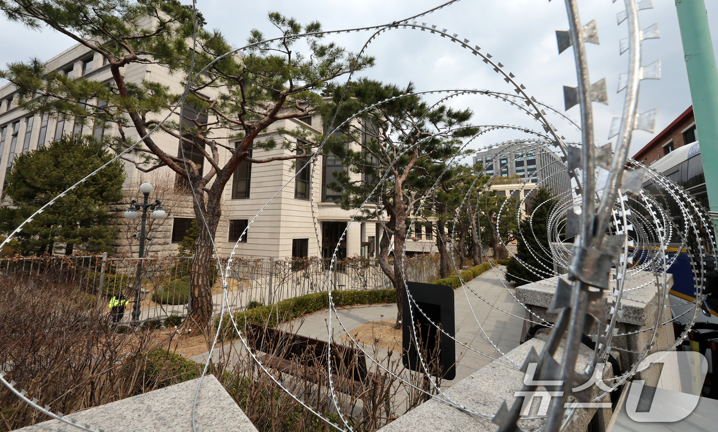 (서울=뉴스1) 이동해 기자 = 윤석열 대통령 탄핵심판 선고를 앞둔 16일 서울 종로구 헌법재판소 담벼락에 원형 철조망이 설치돼 있다. 2025.3.16/뉴스1