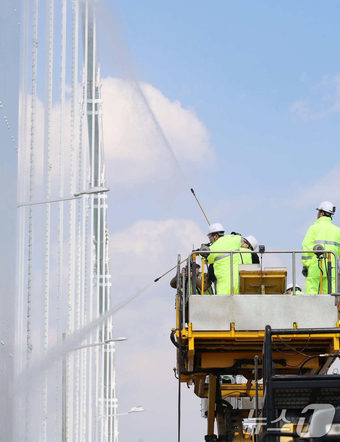(부산=뉴스1) 윤일지 기자 = 17일 오후 부산시설공단 관계자들이 봄을 맞아 부산 광안대교 상판 현수교 주탑을 물청소하고 있다.  2025.3.17/뉴스1