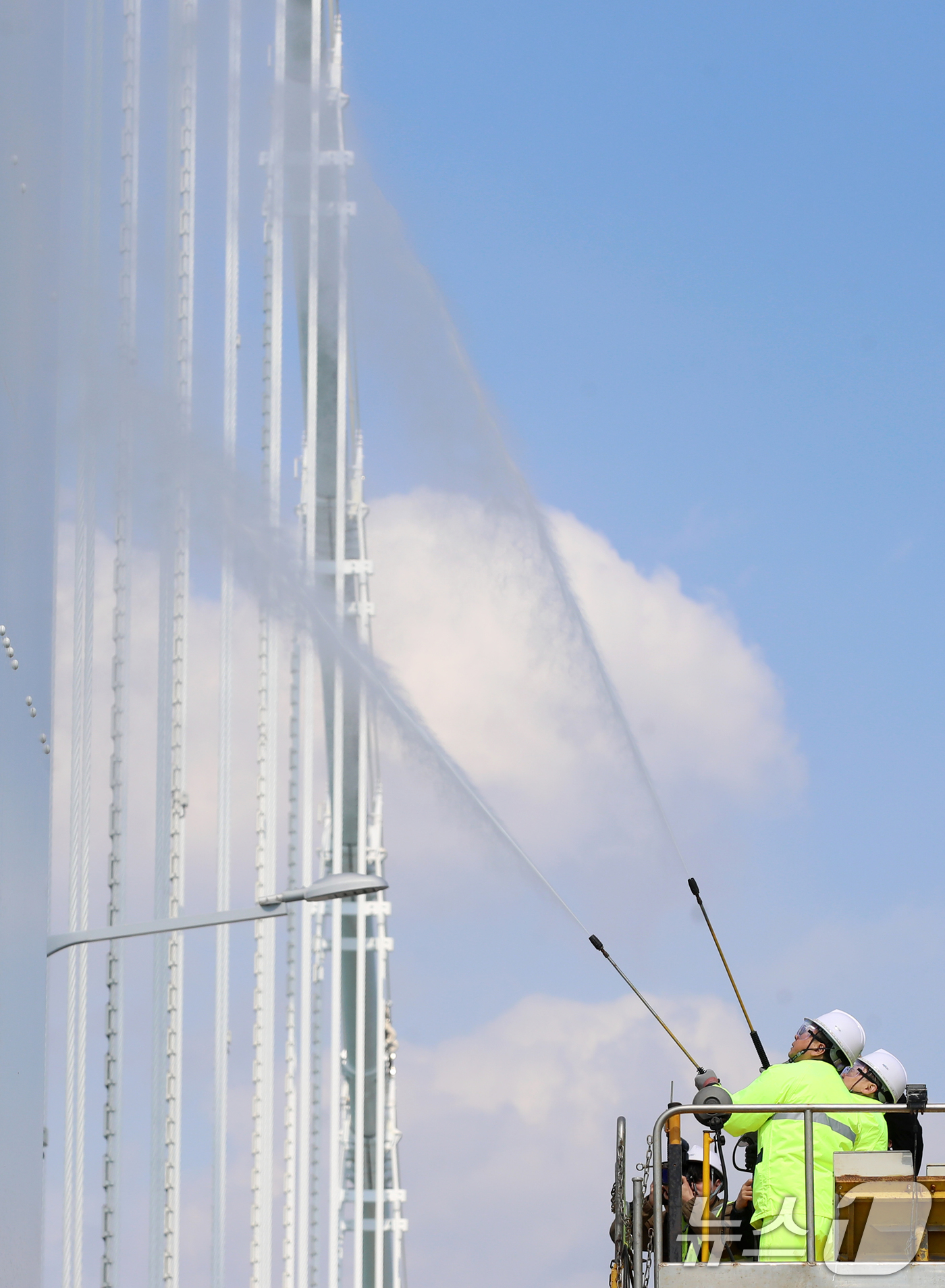 (부산=뉴스1) 윤일지 기자 = 17일 오후 부산시설공단 관계자들이 봄을 맞아 부산 광안대교 상판 현수교 주탑을 물청소하고 있다.  2025.3.17/뉴스1