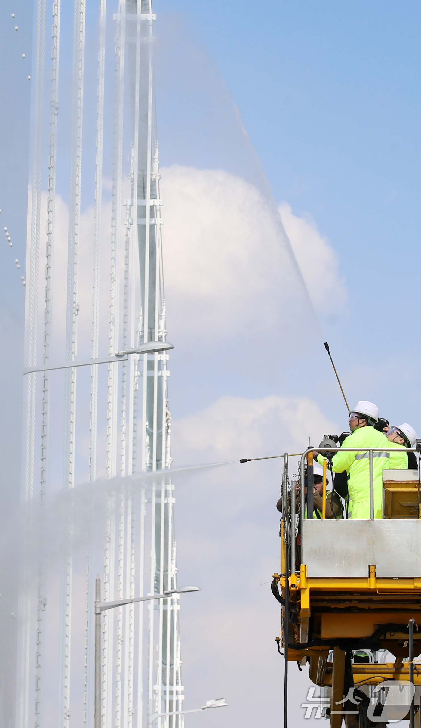 (부산=뉴스1) 윤일지 기자 = 17일 오후 부산시설공단 관계자들이 봄을 맞아 부산 광안대교 상판 현수교 주탑을 물청소하고 있다.  2025.3.17/뉴스1