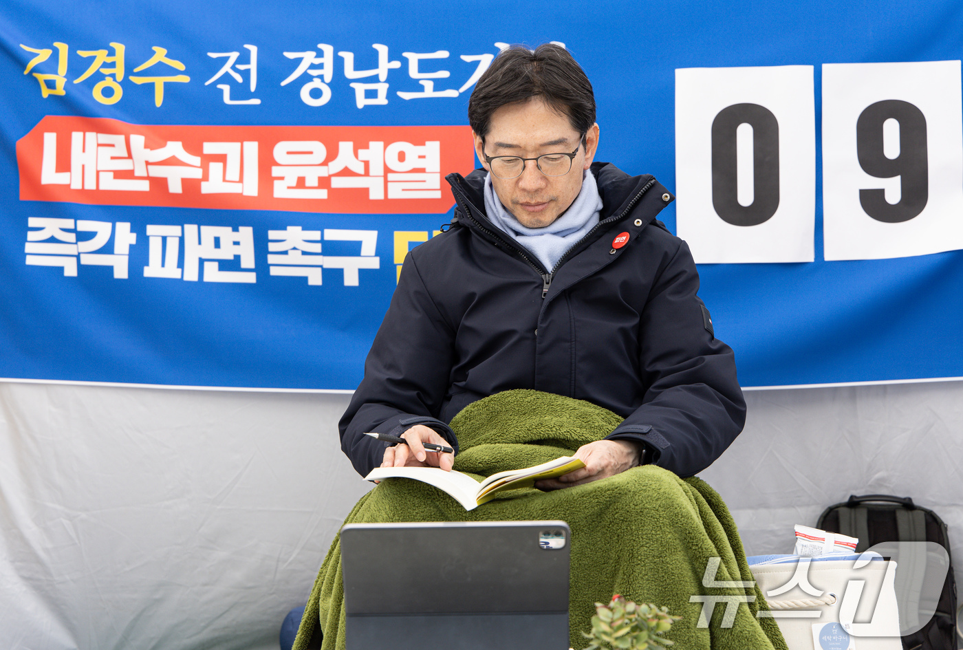 (서울=뉴스1) 이재명 기자 = 윤석열 대통령의 파면을 촉구하며 단식 농성에 나선 김경수 전 경남도지사가 17일 오후 서울 종로구 경복궁역 인근 농성장에서 책을 읽고 있다. 202 …