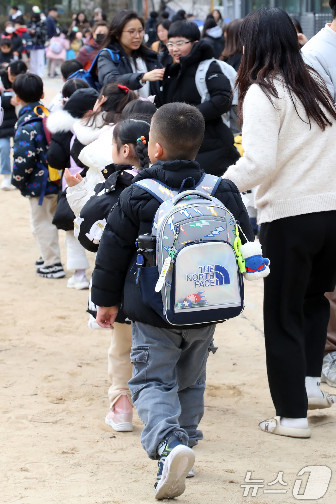 (대구=뉴스1) 공정식 기자 = 17일 오후 대구의 한 초등학교에서 학생들이 교사의 귀가 지도에 따라 하교를 준비하고 있다. 교문 주변은 자녀를 기다리는 학부모와 보호자로 북적이고 …