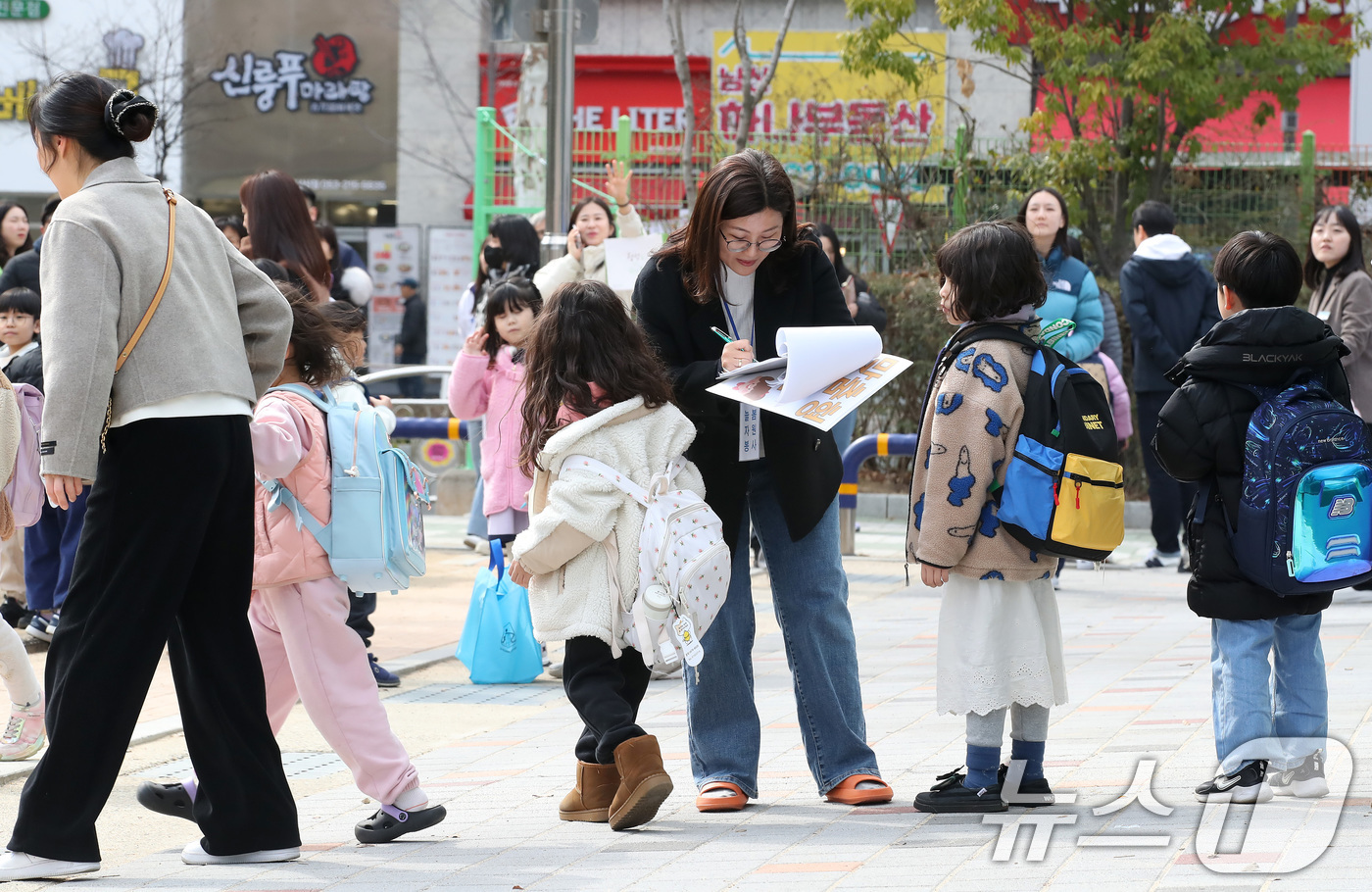 (대구=뉴스1) 공정식 기자 = 17일 오후 대구의 한 초등학교에서 학생들이 교사의 귀가 지도에 따라 하교를 준비하고 있다. 교문 주변은 자녀를 기다리는 학부모와 보호자로 북적이고 …