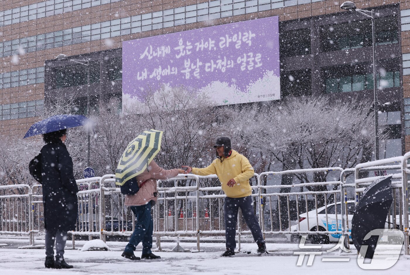 본문 이미지 -   대설주의보가 발효된 18일 오전 서울 광화문광장에서 외국인관광객이 추억을 남기고 있다. 2025.3.18/뉴스1 ⓒ News1 박지혜 기자
