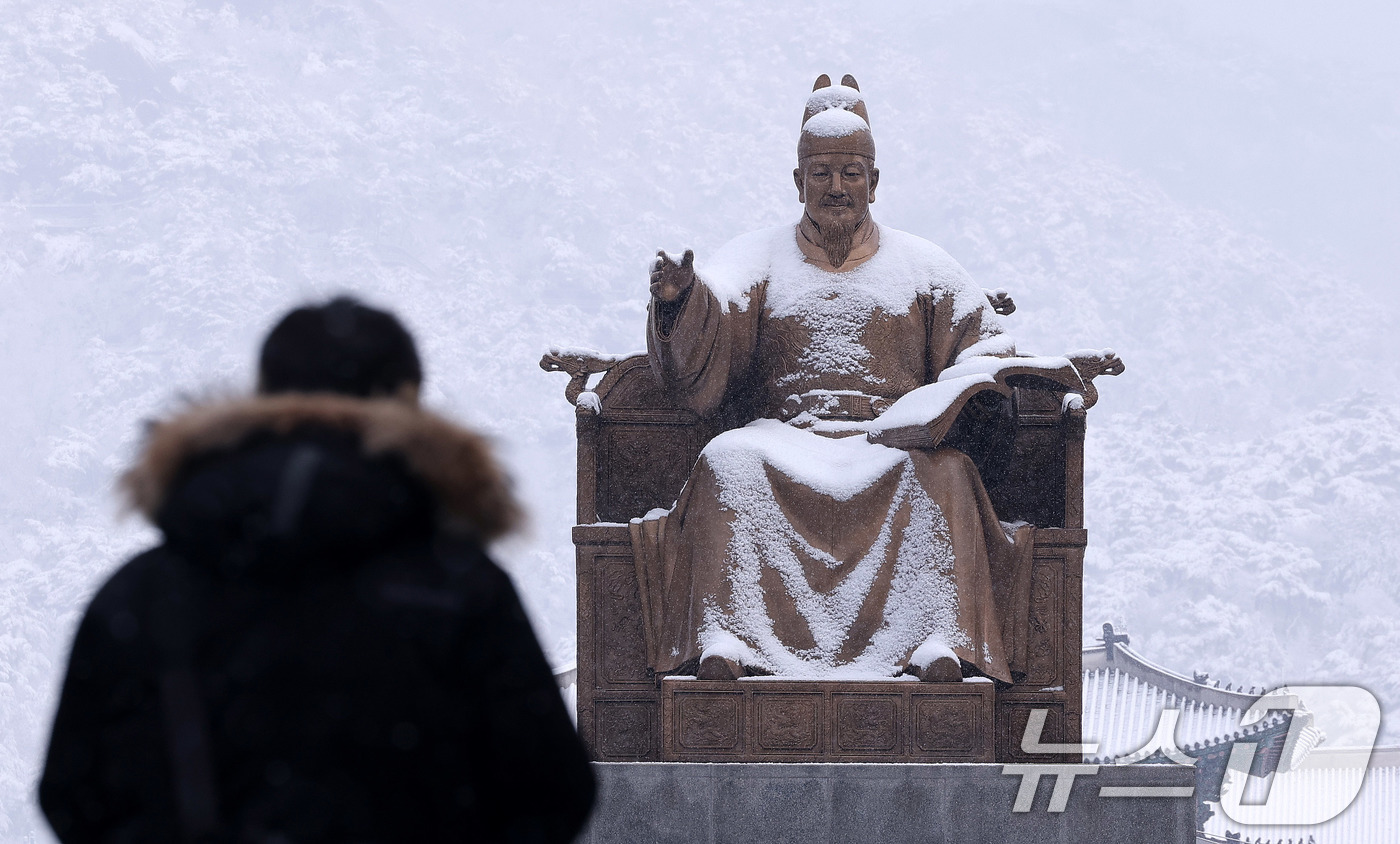 (서울=뉴스1) 박지혜 기자 = 난데없는 3월 대설주의보가 발효된 18일 오전 서울 광화문광장에서 한 시민이 지나가고 있다. 2025.3.18/뉴스1