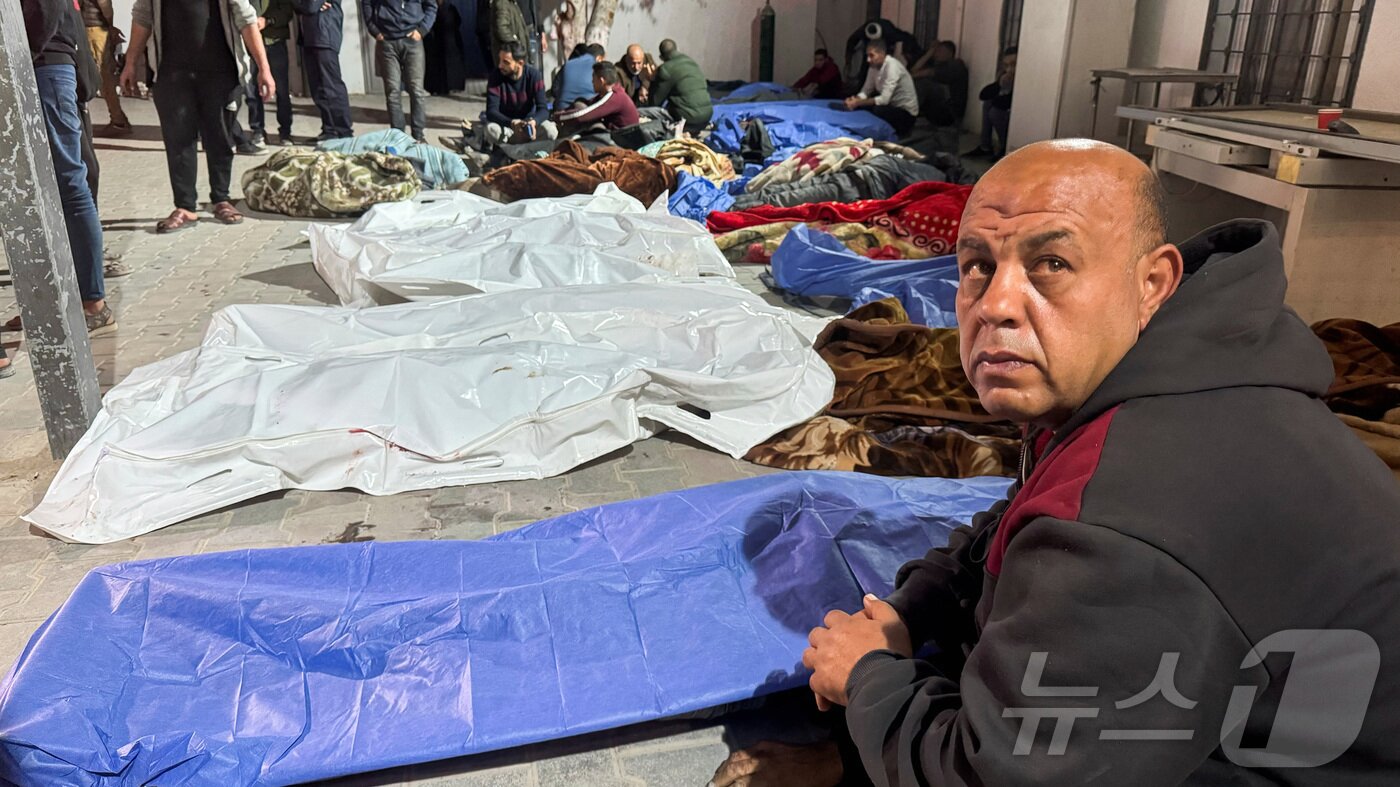 본문 이미지 - 가자지구 한 병원에서 이스라엘 공격으로 사망한 팔레스타인인 시신 근처에 모인 애도자들. ⓒ 로이터=뉴스1