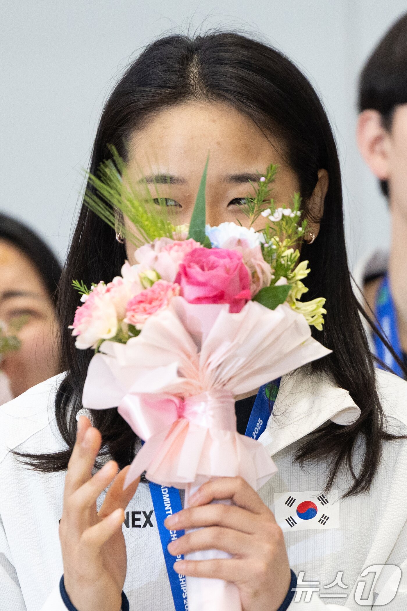 본문 이미지 - 전영 오픈에서 우승을 차지한 배드민턴 안세영이 18일 오후 인천국제공항을 통해 귀국해 기념촬영 중 응원 소리에 쑥스러워하고 있다. 2025.3.18/뉴스1 ⓒ News1 이승배 기자