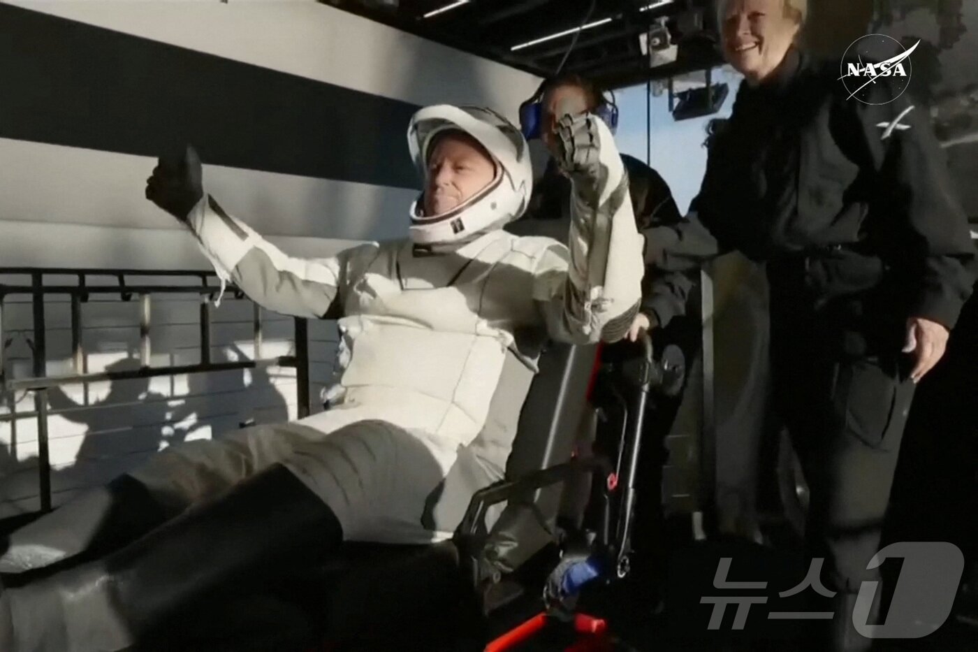 본문 이미지 - NASA 우주 비행사 부치 윌모어가 미국 플로리다주 탤러해시 해안의 물에 착륙한 후  SpaceX Dragon 우주선에서 도움을 받고 있다. ⓒ 로이터=뉴스1