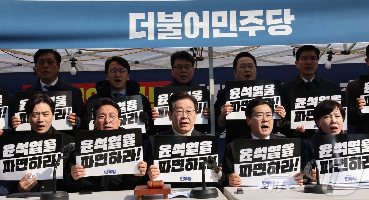 본문 이미지 - 이재명 더불어민주당 대표가 19일 오전 서울 경복궁역 인근에 마련된 민주당 천막농성장에서 열린 최고위원회의에서 손피켓을 들고 구호를 외치고 있다. 2025.3.19/뉴스1 ⓒ News1 국회사진취재단