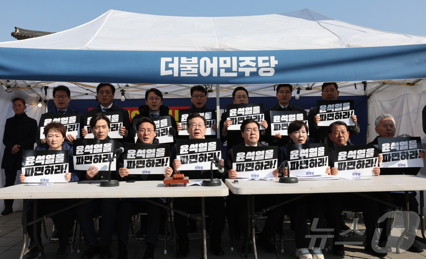 (서울=뉴스1) 국회사진취재단 = 이재명 더불어민주당 대표가 19일 오전 서울 경복궁역 인근에 마련된 민주당 천막농성장에서 열린 최고위원회의에서 손피켓을 들고 구호를 외치고 있다. …