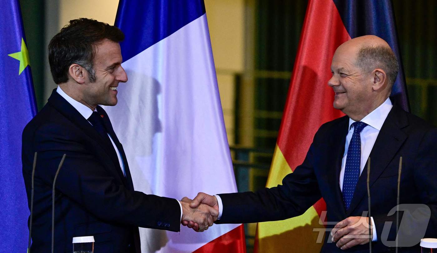 (베를린 AFP=뉴스1) 우동명 기자 = 에마뉘엘 마크롱 프랑스 대통령이 18일(현지시간) 베를린 총리 관저에서 올라프 숄츠 독일 총리와 기자회견을 마친 뒤 악수를 하고 있다. 2 …