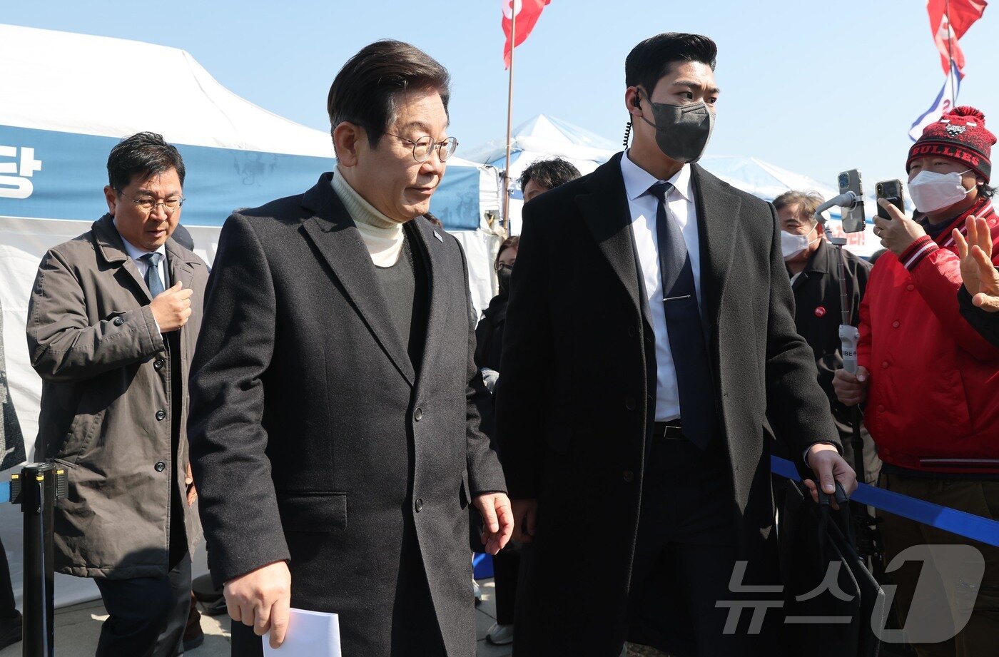 본문 이미지 - 이재명 더불어민주당 대표가 19일 오전 서울 종로구 경복궁역 부근 민주당 천막농성장에서 열린 현장 최고위원회의를 마친 후 차량으로 이동하고 있다. 암살 위협설이 제기된 이 대표는 이날 방탄복을 입고 최고위를 진행했다. 2025.3.19/뉴스1 ⓒ News1 국회사진취재단